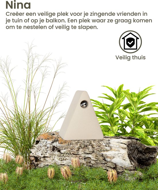 Lichtbeige driehoekige vogelhuisje op een boomstronk met wuivend gras.