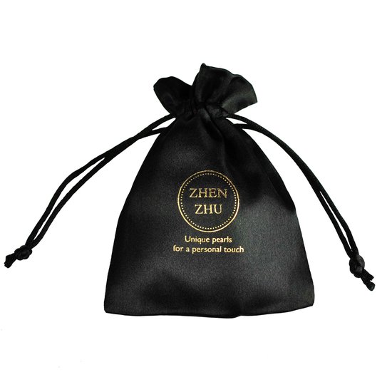 Zwart fluwelen sieradenzakje met goudkleurige opdruk 'ZHEN ZHU' en 'Unique pearls for a personal touch'.