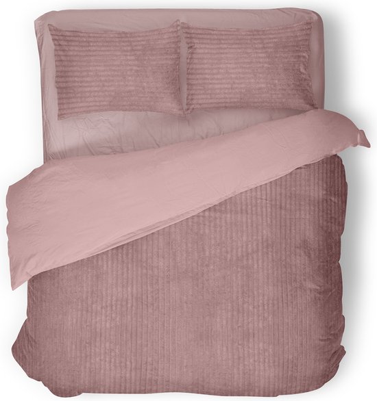 Bovenaanzicht van een roze corduroy dekbedovertrek met verticale ribbels en kussenslopen op een wit oppervlak.