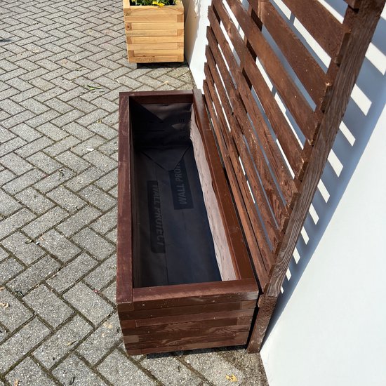 Bruine houten plantenbak met klimrek, leeg, op een betegeld terras.