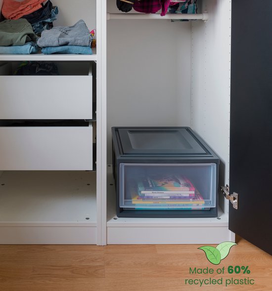 Zwarte opbergdoos met transparante lade, gevuld met boeken, in een open kast.