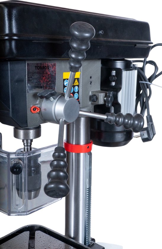 Grijze Torros tafelboormachine met zwarte kap, 3 handgrepen en een transparante beschermkap.