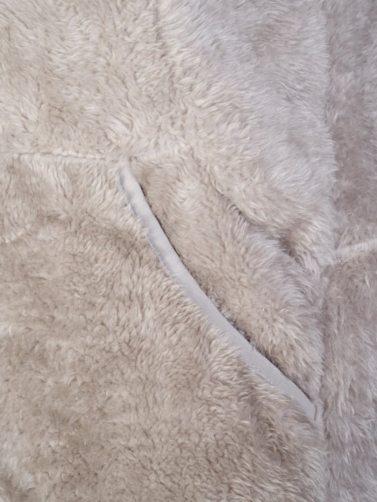 Close-up van een zak op een beige fleece bodywarmer.