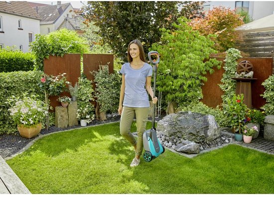 Vrouw loopt met grastrimmer met oranje handvat en blauw-grijze behuizing door een tuin.