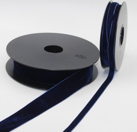 Un rouleau de ruban de velours bleu marine, une extrémité déroulée.