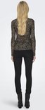 Vrouw met lang blond haar, draagt zwarte skinny jeans en zwarte laarzen, en een mesh top met panterprint.