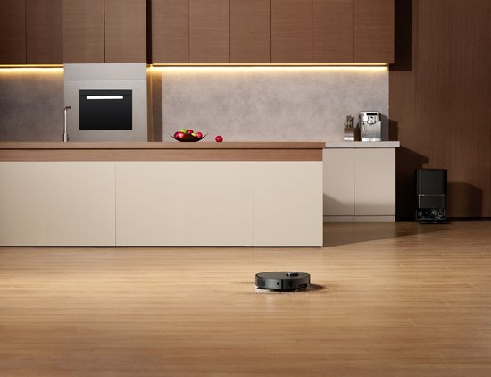 Zwarte robotstofzuiger met dubbele dweilkoppen op een houten vloer in een moderne keuken.
