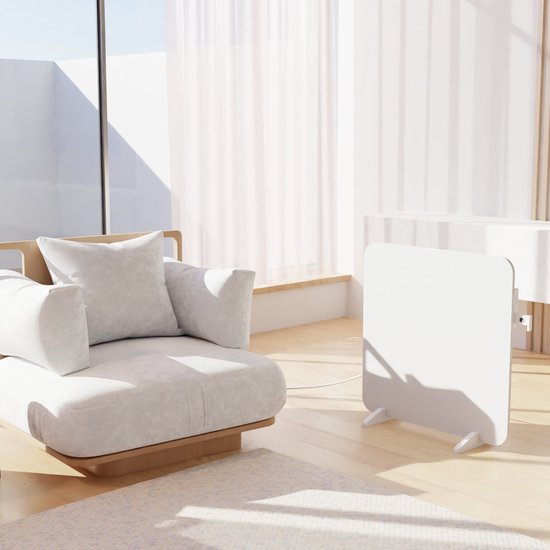Witte paneelradiator staand op houten pootjes in een woonkamer, naast een fauteuil.