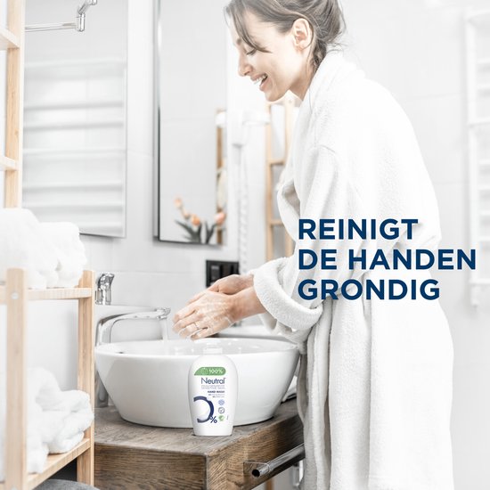 Vrouw in badjas wast haar handen bij de wastafel. Reinigt de handen grondig.
