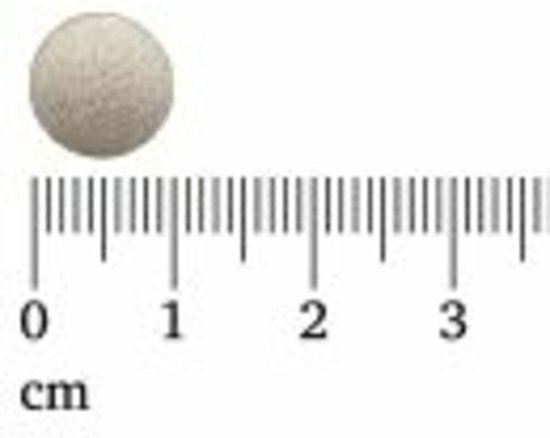 Eén ronde, witte tablet op een liniaal, gemarkeerd in centimeters.
