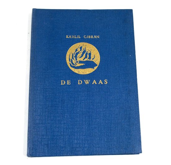 Blauw boek met gouden tekst 'KAHLIL GIBRAN DE DWAA' en een gouden cirkelvormig symbool met handen en vuur.