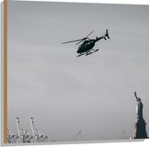 WallClassics - Hout - Helikopter zwevend boven Vrijheidsbeeld in New York - 80x80 cm - 12 mm dik - Foto op Hout (Met Ophangsysteem)