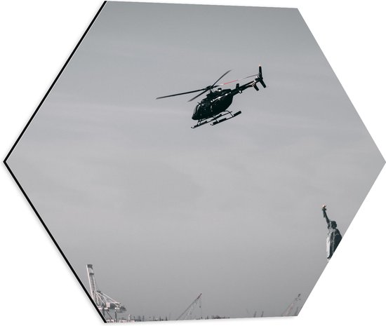 WallClassics - Dibond Hexagon - Helikopter zwevend boven Vrijheidsbeeld in New York - 50x43.5 cm Foto op Hexagon (Met Ophangsysteem)