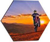 WallClassics - Dibond Hexagon - Motorrijder bij Berglandschap met Zon - 30x26.1 cm Foto op Hexagon (Met Ophangsysteem)
