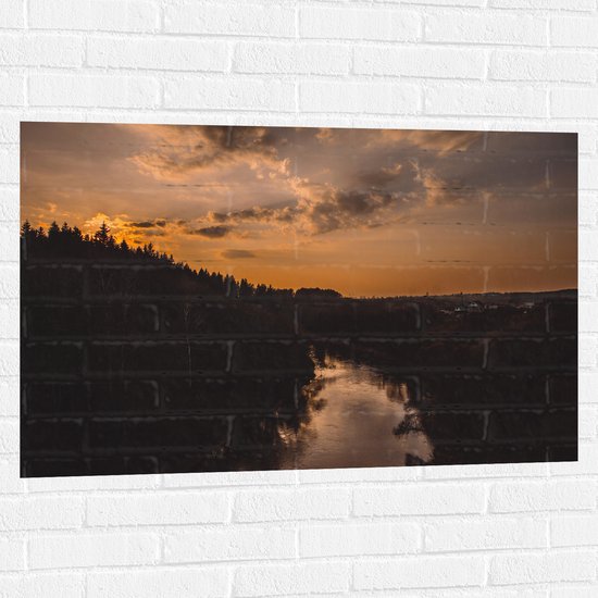 WallClassics - Muursticker - Rivier tussen de Bossen met Zonsondergang - 105x70 cm Foto op Muursticker