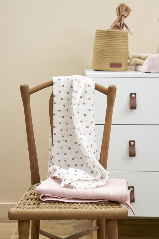 Zachtroze hydrofiele luier en witte luier met panterprint op een houten stoel.