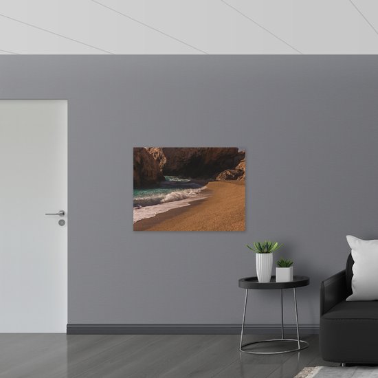 WallClassics - Dibond - Aanspoelende Golven op Strand met Rotsen - 100x75 cm Foto op Aluminium (Wanddecoratie van metaal)