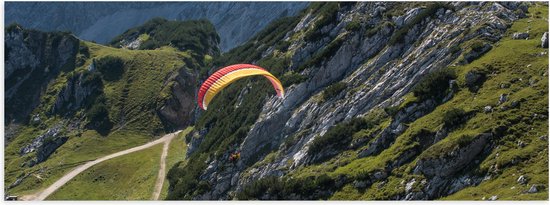WallClassics - Poster (Mat) - Paraglidend door de Bergen en Natuur - 150x50 cm Foto op Posterpapier met een Matte look