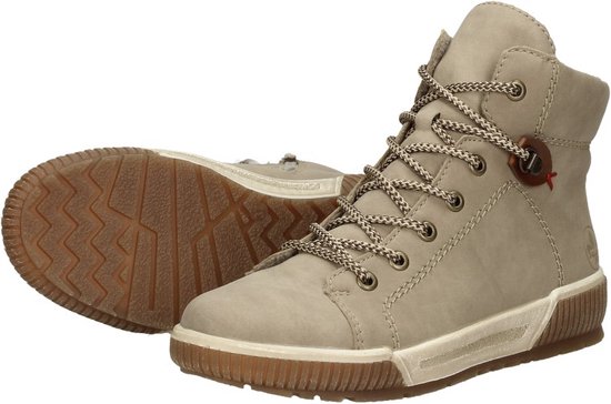Beige hoge veterschoenen met bruine veters en bruine zolen. De linkerschoen ligt.