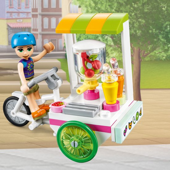 LEGO Friends Mia in blauwe helm op een smoothiekar met een sapcentrifuge.