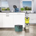 Keuken met witte kasten. Blauwe bak, groene bak en een stapel gele, witte, grijze bakken.