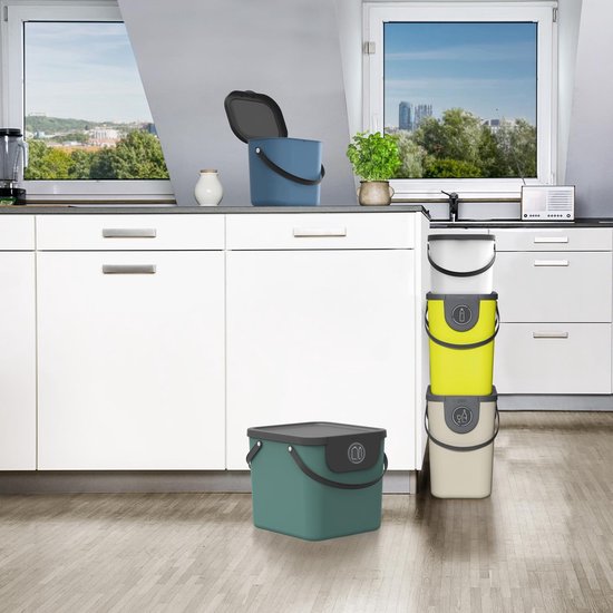 Keuken met witte kasten. Blauwe bak, groene bak en een stapel gele, witte, grijze bakken.