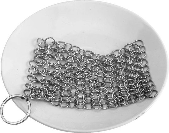 Zilverkleurige metalen schuurspons met ring, op een wit bord.