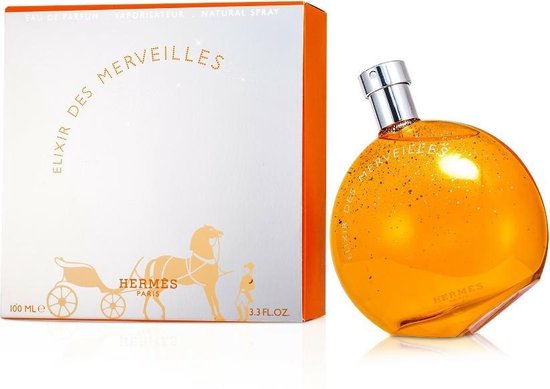 Elixir des Merveilles Eau de Parfum, 100 ml (3.3 FL.OZ). Doos met paard en wagen en parfumflesje, wit met oranje accenten.
