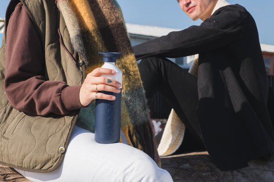 Close-up van handen met Dopper Insulated fles in Breaker Blue.