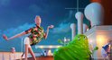 Een man in een Hawaiiaans shirt danst op het dek van een cruiseschip met een groene slijmfiguur.