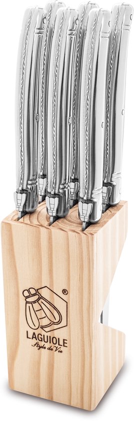 Een houten blok met zes Laguiole steakmessen, met zilverkleurige handvatten en gekartelde lemmeten.