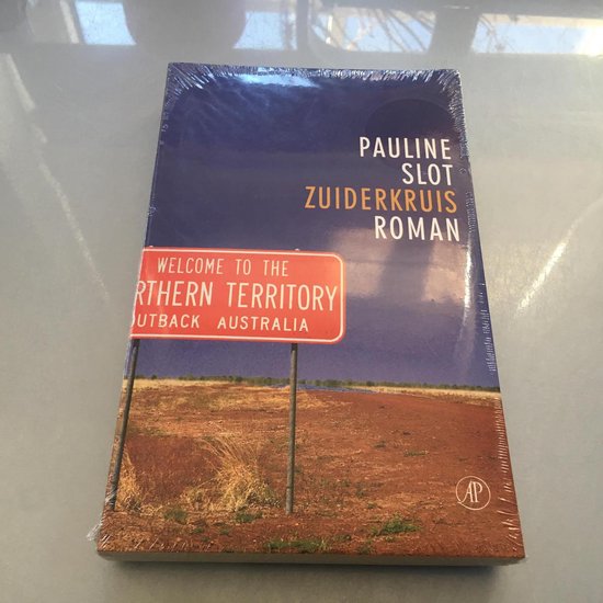 Boek 'Zuiderkruis' van Pauline Slot. Cover met een rode wegwijzer 'Welcome to the Northern Territory Outback Australia' tegen een donkere lucht en woestijnlandschap.