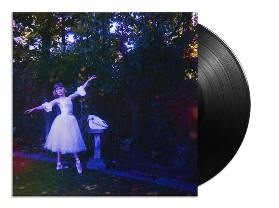 LP hoes met een ballerina in een witte tutu op balletpunten, in een tuin met een schedel op een sokkel.