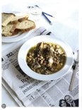 Schaal met soep, brood, glas water en potloden op een krant.