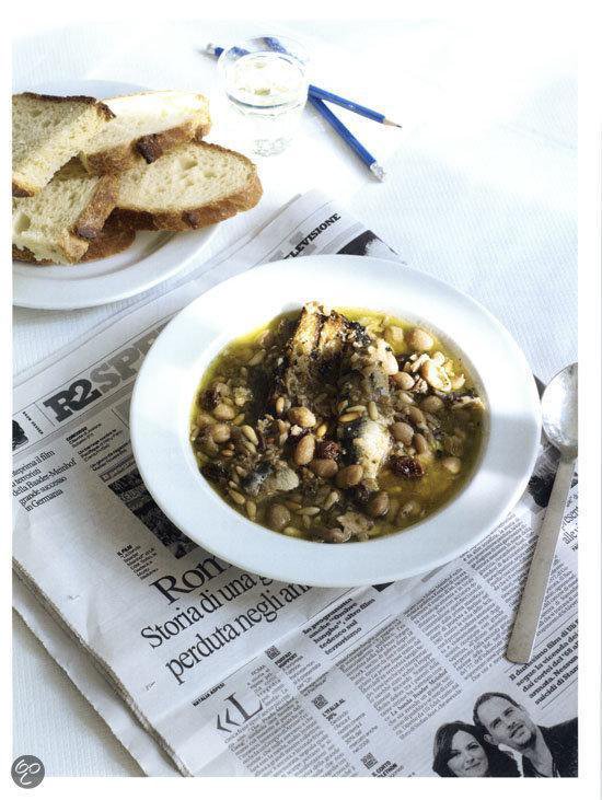 Schaal met soep, brood, glas water en potloden op een krant.