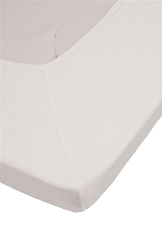 Close-up van een wit jersey topper hoeslaken, met elastische band zichtbaar.