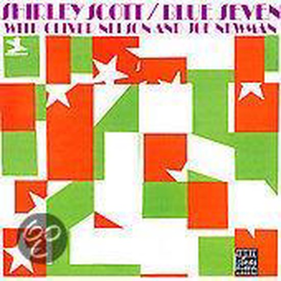 Albumhoes met de tekst 'SHIRLEY SCOTT / BLUE SEVEN' boven een abstract patroon van rode en groene vierkanten met witte sterren. Links onderaan een vogel-logo en rechts onderaan een tekst-logo.