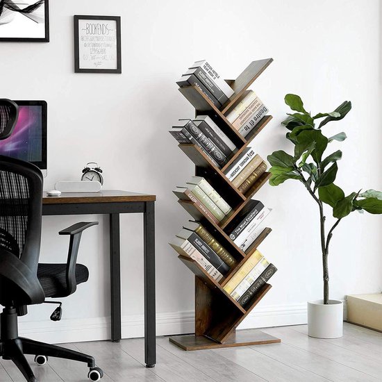 Boekenkast in boomvorm in een kantoorruimte, naast een bureau en een plant.