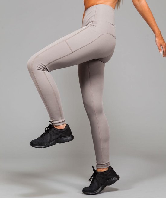 Vrouw in beweging met een lichtgrijze sportlegging met zakken. Marrald logo op de heup.