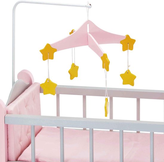 Gedetailleerde foto van de roze kussens en het grijze bedframe met sterrenmobiel boven een poppenbedje.
