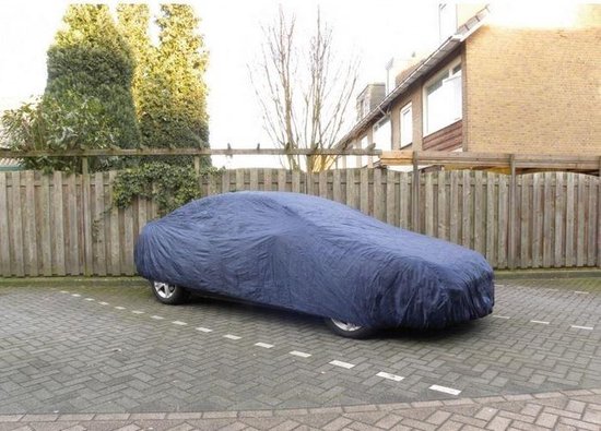 Donkerblauwe autohoes over een auto, geparkeerd op een stenen ondergrond.