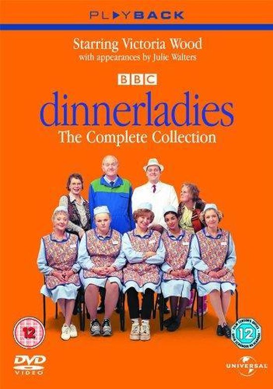 De cast van Dinnerladies, inclusief Victoria Wood, in hun schooluniformen met schorten, zittend en staand.