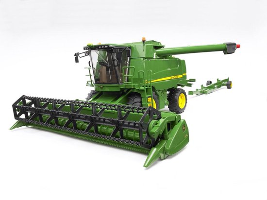 Groene John Deere T670i combine met gele wielen en maaibord, op een witte achtergrond.