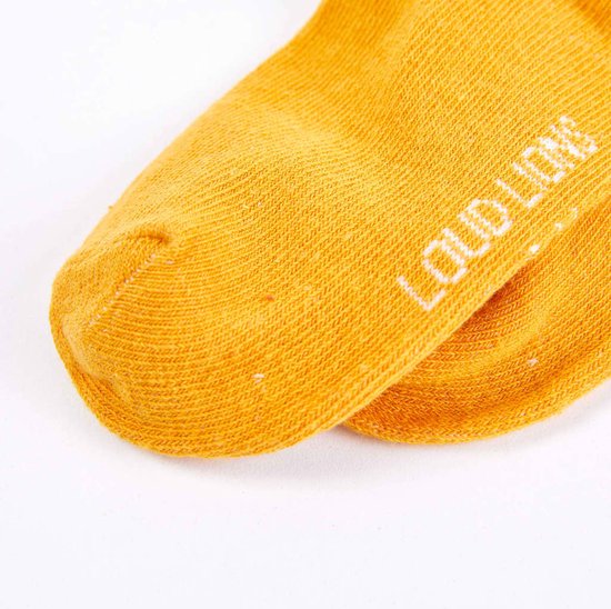 Okergele maillot met de merknaam 'LOUD + PROUD' in witte letters op de wreef.