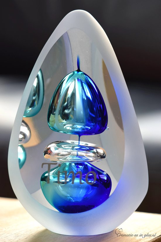Glazen urn met druppelvormige omhulsel en blauwe bubbels in het midden. Tekst 'Time' zichtbaar.