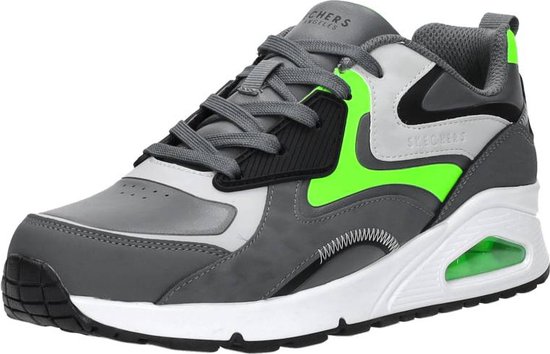 Grijze sneaker met neon-groene accenten, vetersluiting en witte zool met luchtunit.