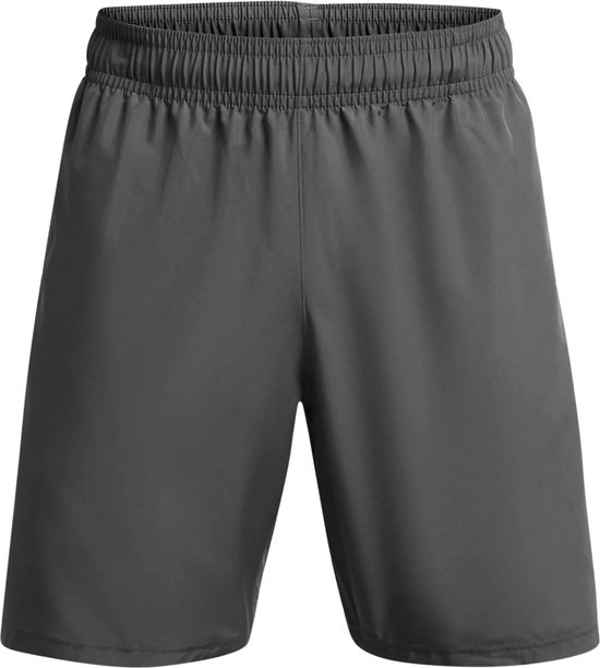 Grijze sportbroek van Under Armour met witte tekst op de zijkant, gedragen door een man.