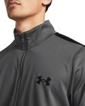 Grijs trainingsjack met zwarte strepen op de mouwen en een zwart Under Armour logo.