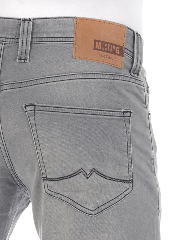 Grijze spijkerbroek met bruin Mustang 'True Denim' label op de achterkant.
