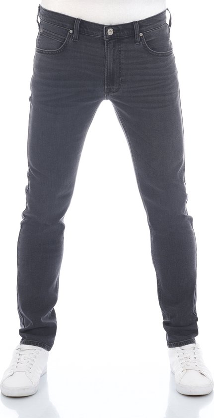 Model in donkergrijze jeansbroek, slim fit, met witte sneakers.